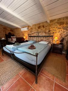 ein großes Bett in einem Zimmer mit einer Steinmauer in der Unterkunft Finca Es Velar in Santanyi