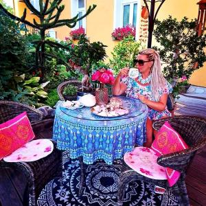een vrouw aan een tafel met een kopje thee bij Hostel Sonce in Ptuj