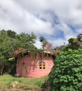 uma casa rosa com flores em cima em Sítio Monte Alegre em Ibicoara