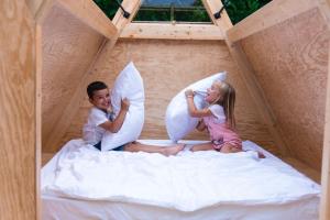 un garçon et une fille assis sur un lit dans une tente de jeu dans l'établissement SKY HOUSE EXPERIENCE, à Salmore