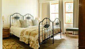 1 dormitorio con 1 cama con marco de metal en Baris Guesthouse en Clarens