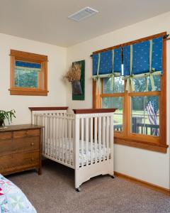 a nursery with a crib and a window at Adventures From Bozeman's Perfect Location in Bozeman