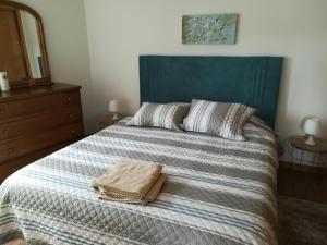 a bedroom with a bed with a blanket and a mirror at Rivers Nation Surf Camp in Atouguia da Baleia