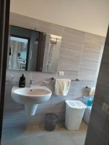 ein Badezimmer mit einem Waschbecken, einem WC und einem Spiegel in der Unterkunft SGM CASA VACANZE in Masainas