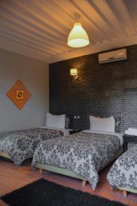 - une chambre avec 2 lits et un mur en briques dans l'établissement Dar Riad Niama, à Taroudant