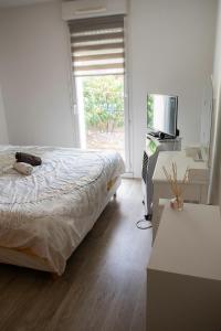 um quarto com uma cama, uma televisão e uma janela em T3 bord de Seine,proche centre ville,parking privé em Mantes-la-Jolie