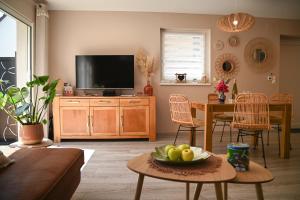 a living room with a television and a table with a bowl of fruit at 214 A‘coeur in Hindisheim