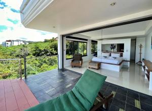 a bedroom in a villa with a bed and a balcony at Andaman Hills - panoramic sea view house in Patong in Patong Beach