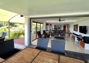 a living room with a table and chairs at Andaman Hills - panoramic sea view house in Patong in Patong Beach