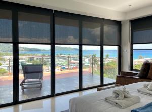a bedroom with a view of the ocean at Andaman Hills - panoramic sea view house in Patong in Patong Beach