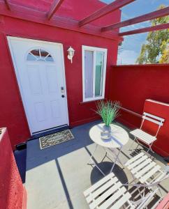 a red house with a white door and chairs at Newly remodeled 1 bed, 1 bath home near LAX, Forum in Inglewood