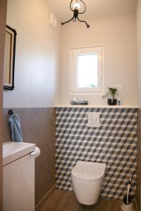 a bathroom with a toilet and a sink and a window at 214 A‘coeur in Hindisheim