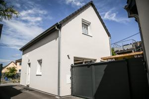 una casa blanca con una puerta de garaje negra en 214 A‘coeur, en Hindisheim