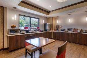 uma cozinha com mesa e cadeiras num quarto em Best Western Plus Orlando East - UCF Area em Orlando