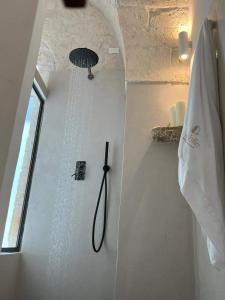 una ducha con una manguera colgada en la pared en Nobile Dimora di Puglia en Ostuni