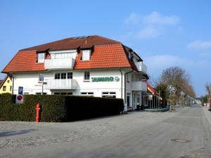 a white building with an orange roof on a street at Strandstr_55 Wohng_5 in Zingst