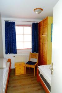 a bedroom with a bed and a window with blue curtains at Strandstr_55 Wohng_5 in Zingst