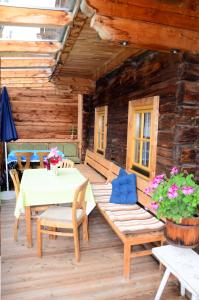 patio ze stołem i krzesłami oraz drewnianą kabiną w obiekcie Ferienhaus Schett w mieście Innervillgraten