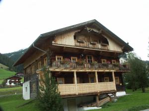 ein großes Holzhaus mit Balkonen und Blumen darauf in der Unterkunft Ferienhaus Schett in Innervillgraten