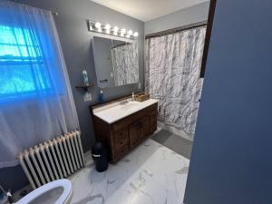 W łazience znajduje się umywalka i lustro. w obiekcie 4 bedrooms & 2 bathrooms “Dhanu’s place” w mieście Scranton