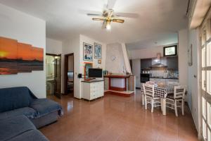 sala de estar con sofá, mesa y cocina en Villa Susy, en Punta Prosciutto