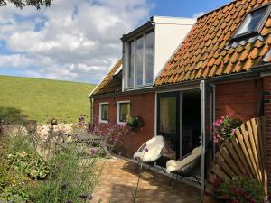 una casa de ladrillo con 2 sillas en un patio en Wad'n Dream, en Moddergat