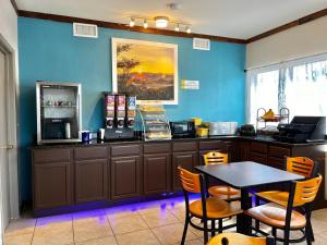 ein Restaurant mit einem Tisch und einer blauen Wand in der Unterkunft Days Inn by Wyndham Suites Fredericksburg in Fredericksburg