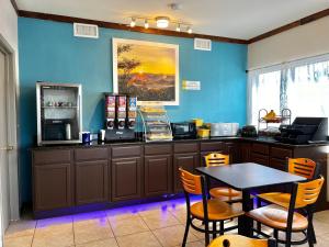 a restaurant with a table and a blue wall at Days Inn by Wyndham Suites Fredericksburg in Fredericksburg
