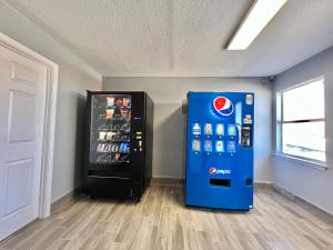 a soda vending machine in a room next to a door at Days Inn by Wyndham Suites Fredericksburg in Fredericksburg