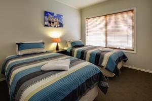 a bedroom with two beds and a window at Reardon Place in Port Fairy