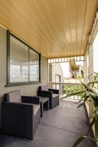 eine Terrasse mit Korbstühlen und Tischen auf einem Balkon in der Unterkunft Reardon Place in Port Fairy