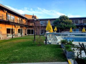 un complejo con piscina, sillas y sombrillas en Marvic Hotel en San Pedro