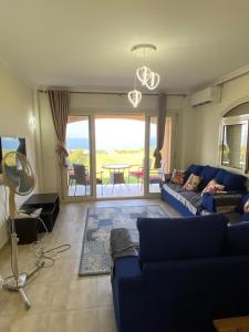 艾因蘇赫納的住宿－Telal Ain Sokhna Villa，客厅配有蓝色的沙发和桌子