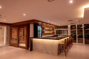 een bar in een wijnkelder met krukken bij Gaben Hotel in Jaú