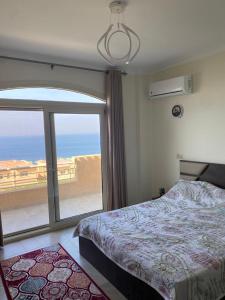 a bedroom with a bed and a large window at Telal Ain Sokhna Villa in Ain Sokhna