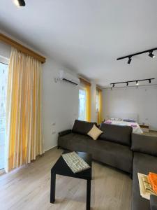 a living room with a couch and a bed at Studio Apartment in Sarandë
