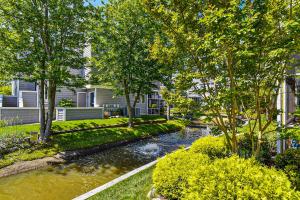 a river in front of a house with trees at East of the Sun --- 39620 East Sun Drive #726 in Fenwick Island