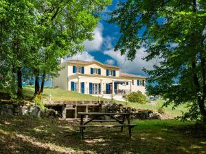 Una casa con una mesa de picnic delante de ella. en Villa de Montaigu, en Montaigu-de-Quercy