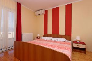Schlafzimmer mit einem Bett mit roten und weißen Streifen in der Unterkunft Double Room Vrbnik 5299b in Vrbnik