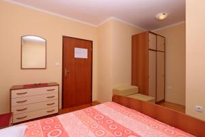 sypialnia z łóżkiem, komodą i lustrem w obiekcie Double Room Vrbnik 5299b w mieście Vrbnik +13 zdjęć