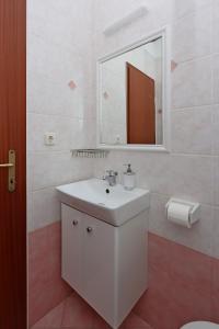 uma casa de banho com um lavatório branco e um espelho. em Double Room Vrbnik 5299b em Vrbnik