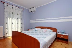 a bedroom with a large bed with blue walls at Double Room Vrbnik 5299c in Vrbnik