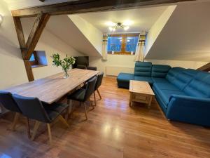 a living room with a blue couch and a table at Apartmán KSlife in Černý Dŭl