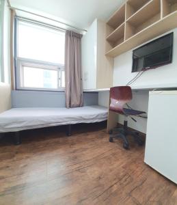 um quarto com uma cama, uma janela e uma cadeira em Apgujeong Home em Seul