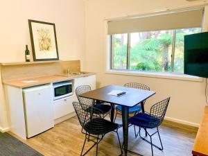 a kitchen with a table and chairs and a sink at The Warby, where mid-century style meets the mountains in Warburton