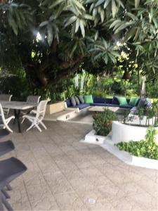 a patio with a table and chairs and a tree at Condominio El Peñon in Girardot