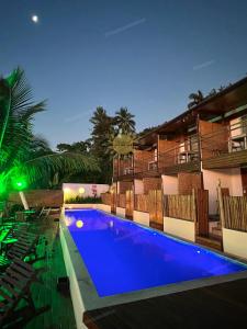 a swimming pool in front of a hotel at night at Residencial Solariun Ilhabela in Ilhabela