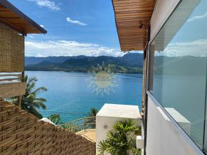 a view of the water from the balcony of a house at Residencial Solariun Ilhabela in Ilhabela