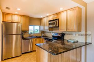 a kitchen with wooden cabinets and a stainless steel refrigerator at Bay Oaks 75 in Siesta Key