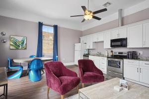 a kitchen with white cabinets and purple chairs and a table at The Balcony House II in New Orleans